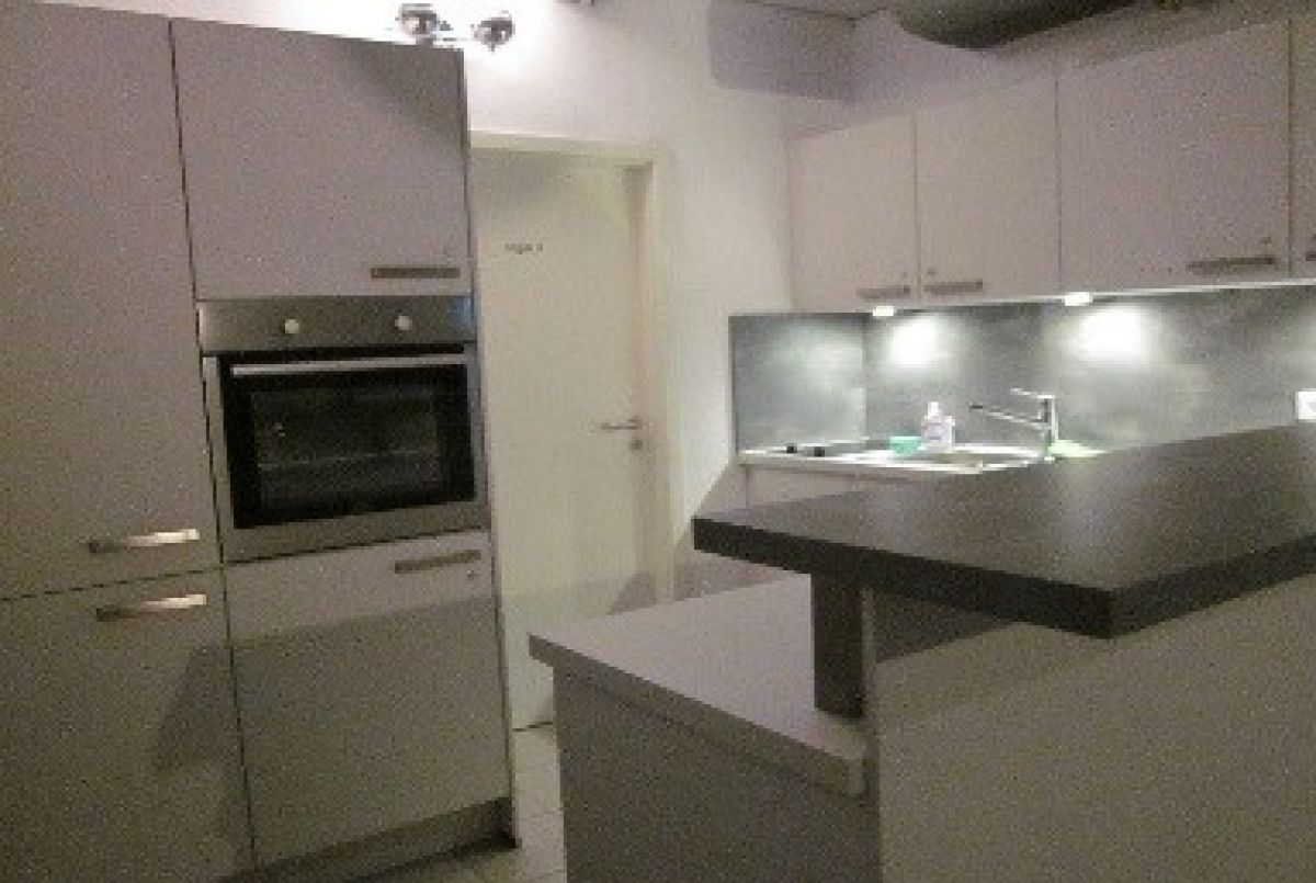 Küche mit Kühlschrank, Backofen und Herdplatte