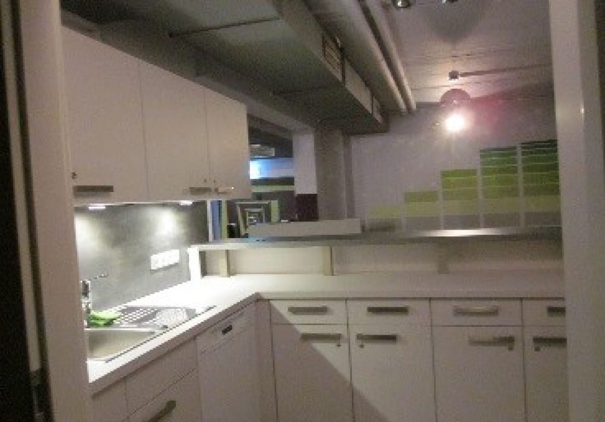 Küche mit Kühlschrank, Backofen und Herdplatte